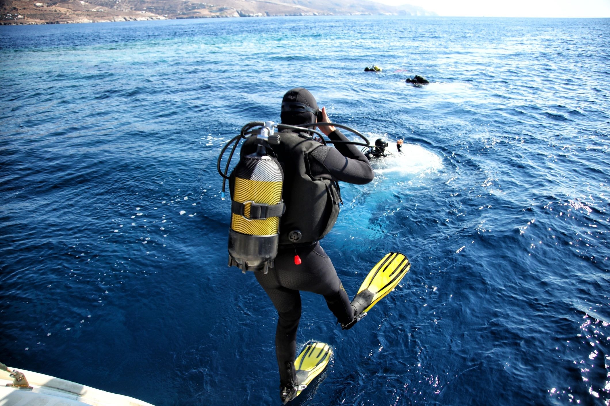 Buzo entrando al océano con aletas amarillas